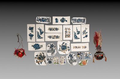 22 Chinese embroidered silk ornaments, a headpiece and a pouch, 18/19th C.