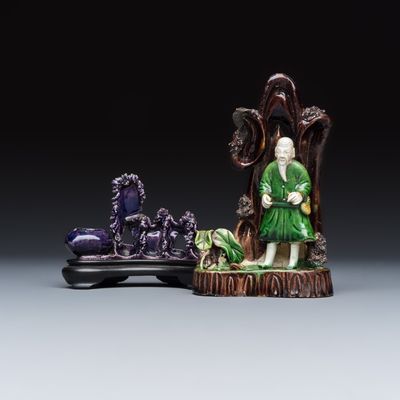 A Chinese aubergine-glazed brush rest and a famille verte sancai biscuit group, Kangxi