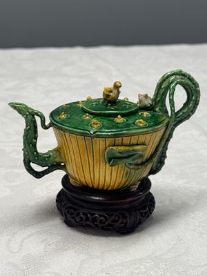A Chinese famille verte sancai biscuit 'Lotus' teapot on a later wooden stand — photo 1