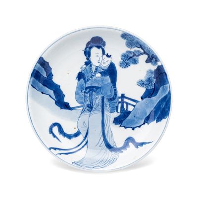 A fine Chinese blue and white semi-eggshell plate with a lady carrying a child, fang ding mark, Kangxi