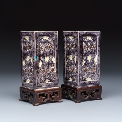A pair of Chinese aubergine-glazed openworked square brush pots on later wooden stands, Kangxi