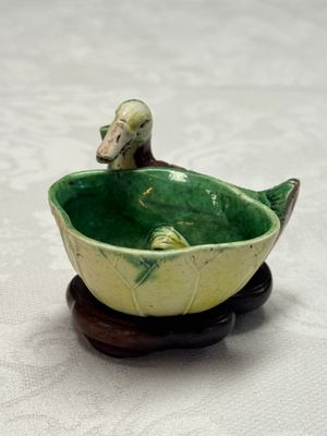 A pair of Chinese famille verte sancai biscuit duck-and-lotus-form water droppers on later wooden stands — photo 31