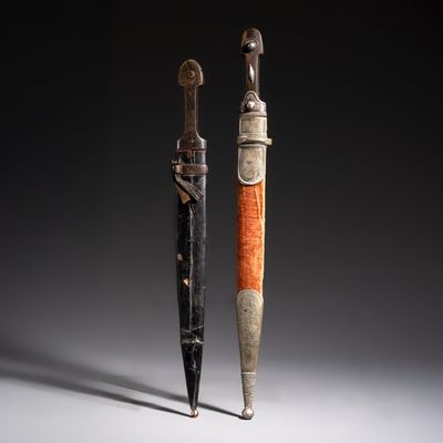 Two Caucasian Kindjal daggers with horn hilts, one with a gilt-iron-mounted leather scabbard and one with a metal-mounted velvet scabbard, 18/19th C.