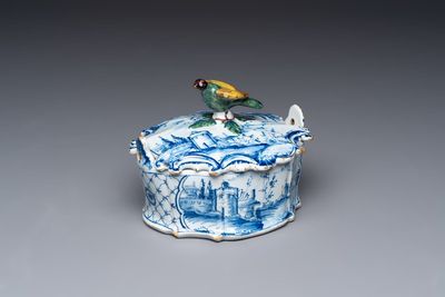 A blue and white Dutch Delft butter tub with a polychrome bird-shaped finial, 18th C.