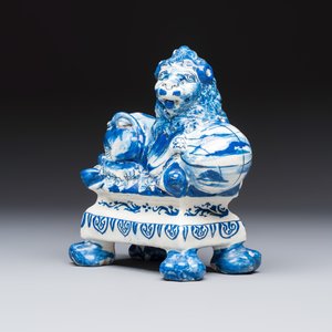 A blue and white Dutch Delft model of a recumbent lion holding a globe — 照片 1