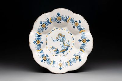 A blue, white and yellow Dutch Delftware dish with a putto, Delft or Haarlem, 17th C.