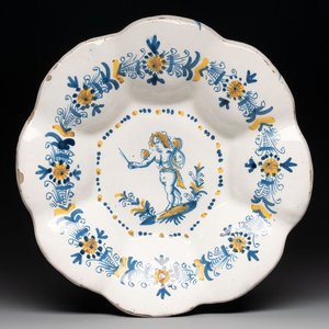 A blue, white and yellow Dutch Delftware dish with a putto, Delft or Haarlem, 17th C. — photo 1
