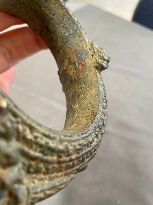 A bronze mirror, a bracelet with a royal or noble emblem and a bronze bracelet with two tiger heads, Cambodia, 12th C. — foto 13