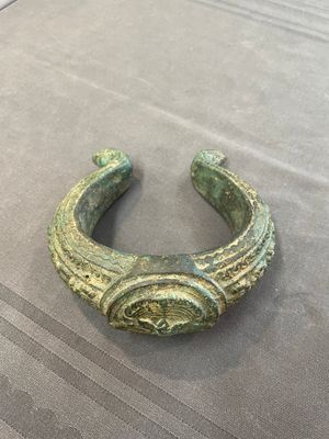 A bronze mirror, a bracelet with a royal or noble emblem and a bronze bracelet with two tiger heads, Cambodia, 12th C. — foto 18