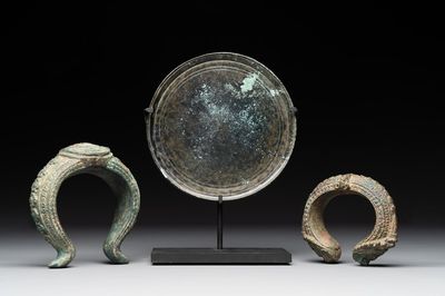 A bronze mirror, a bracelet with a royal or noble emblem and a bronze bracelet with two tiger heads, Cambodia, 12th C.