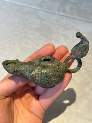 A bronze urn, a bronze canteen with relief design and a pair of bronze oil lamps, Roman Empire, 9th C. B.C/5th C. — foto 3