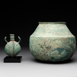 A bronze urn, a bronze canteen with relief design and a pair of bronze oil lamps, Roman Empire, 9th C. B.C/5th C. — foto 3