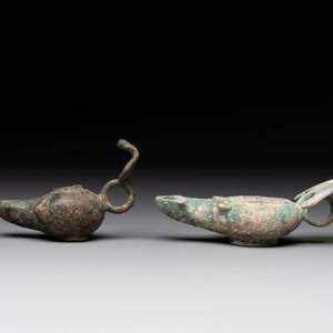 A bronze urn, a bronze canteen with relief design and a pair of bronze oil lamps, Roman Empire, 9th C. B.C/5th C. — foto 6