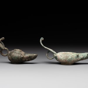 A bronze urn, a bronze canteen with relief design and a pair of bronze oil lamps, Roman Empire, 9th C. B.C/5th C. — foto 7