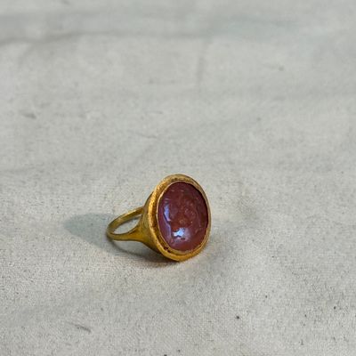 A carnelian intaglio depicting a wolf attacking a stag, set in a gold ring — photo 1