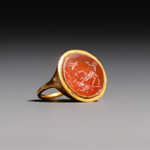A carnelian intaglio depicting a wolf attacking a stag, set in a gold ring — photo 1