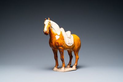A Chinese amber- and cream-glazed pottery model of a horse, Tang