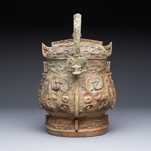 A Chinese archaic bronze wine vessel and cover with Taotie design, You 卣, late Shang — photo 1