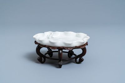 A Chinese blanc de Chine 'frog on lotus flower' brushwasher on carved wooden 'lotus' stand, Kangxi/Yongzheng