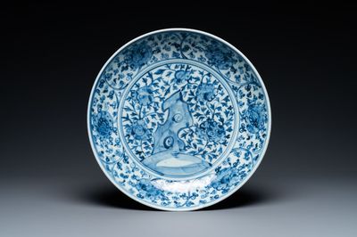 A Chinese blue and white dish with rockwork surrounded by flowers, Ming