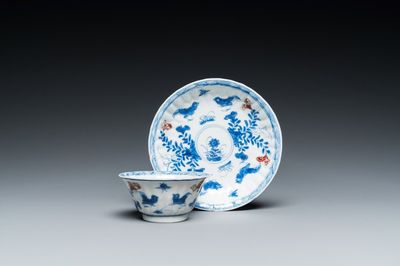 A Chinese blue, white and copper-red cup and saucer, Kangxi