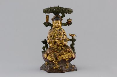 A Chinese bronze and gilt Buddha with child, seated beneath a bodhi tree, 17/18th C.