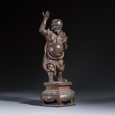 A Chinese bronze figure of a foreigner standing on a pedestal, 17/18th C.