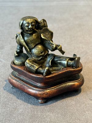 A Chinese bronze paperweight in the form of 'Shi De 拾得' on wooden stand, 16th C. — foto 1