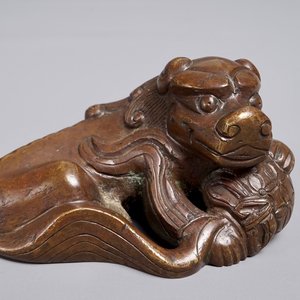 A Chinese bronze scroll or paper weight shaped as a Buddhist lion or Shishi with a ball, 17/18th C. — photo 1