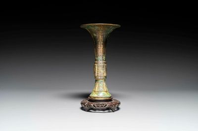 A Chinese bronze Shang-style 'gu' vase on wooden stand, 19/20th C.