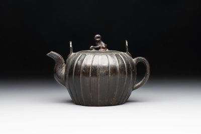 A Chinese bronze teapot and cover with a lion-shaped finial, Yuan