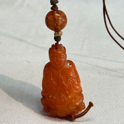 A Chinese carved amber pendant of a Bodhisattva — photo 1