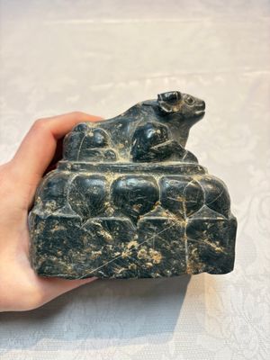 A Chinese carved black stone paper weight in the shape of a reclining buffalo on a lotus throne, Northern and Southern dynasties — photo 1