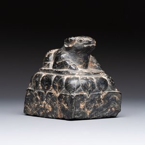 A Chinese carved black stone paper weight in the shape of a reclining buffalo on a lotus throne, Northern and Southern dynasties — photo 1