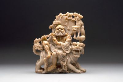 A Chinese carved group of a Luohan with two tigers, 20th C.