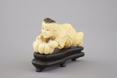 A Chinese carved ivory figure of a boy with a pumpkin, 19/20th C.
