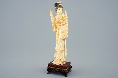 A Chinese carved ivory figure of a lady on wooden base, early 20th C.