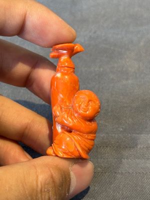 A Chinese carved red coral 'boy and vase' snuff bottle and stopper, 19th C. — photo 1