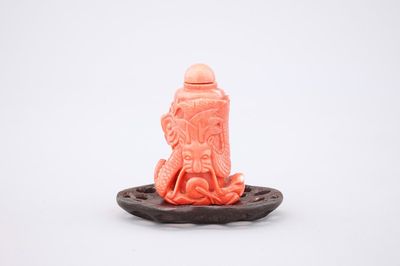 A Chinese carved red coral dragon snuff bottle on stand, 19th C.