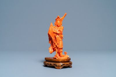 A Chinese carved red coral figure of a warrior holding a flag, 19/20th C.