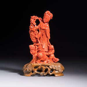 A Chinese carved red coral 'Goddess and Boys' group on a wooden stand, 19/20th C. — photo 1