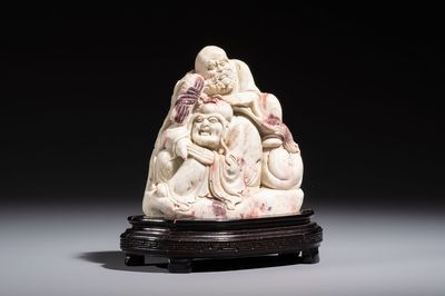 A Chinese carved soapstone 'Luohan' group on a wooden stand, Republic