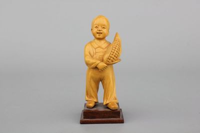 A Chinese carved wood figure of a boy with corn, Cultural Revolution, 20th C.
