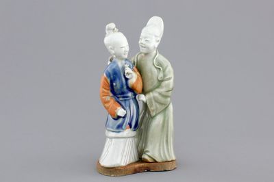 A Chinese celadon and blue-white biscuit group of a couple, Qianlong, 18th C.