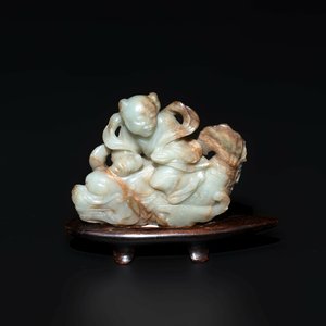 A Chinese celadon and russet jade figure of a boy riding a dragon carp, Qing — photo 1