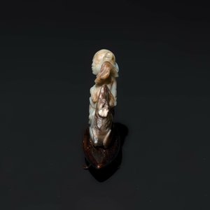 A Chinese celadon and russet jade figure of a boy riding a dragon carp, Qing — photo 5