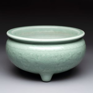 A Chinese celadon-glazed tripod censer with floral anhua design, 18/19th C. — photo 1