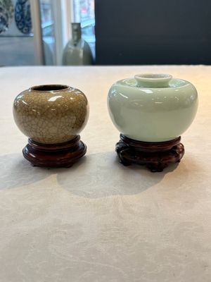 A Chinese celadon-glazed water pot and a ge-type water pot on wooden stands, Qianlong mark, 19th C. — photo 1
