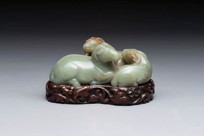 A Chinese celadon jade group of three goats on wooden stand, 19/20th C.