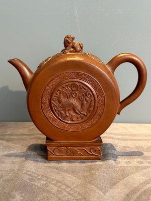 A Chinese circle-shaped Yixing stoneware 'kylin' teapot with relief design, Kangxi — photo 1